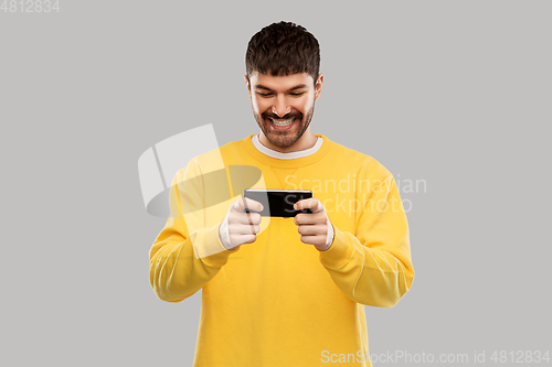 Image of happy smiling young man with smartphone