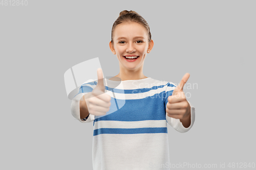 Image of smiling teenage girl showing thumbs up