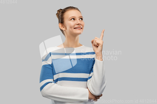 Image of happy teenage girl in pullover pointing finger up