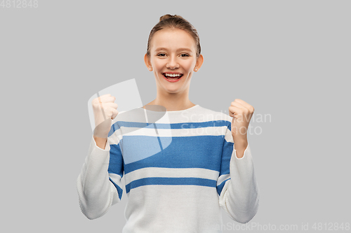 Image of happy teenage girl in pullover celebrating success