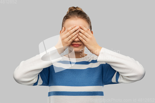 Image of teenage girl closing eyes with hands