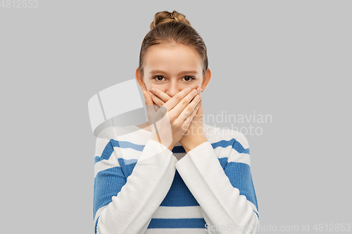 Image of teenage girl covering mouth by hands