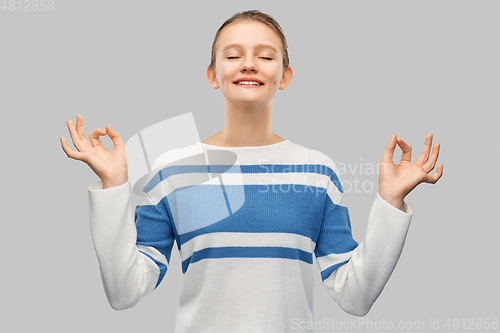 Image of happy smiling teenage girl in pullover meditating