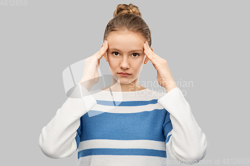 Image of teenage girl having headache over grey background