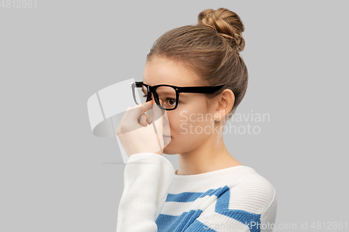 Image of teenage girl in glasses rubbing nose bridge