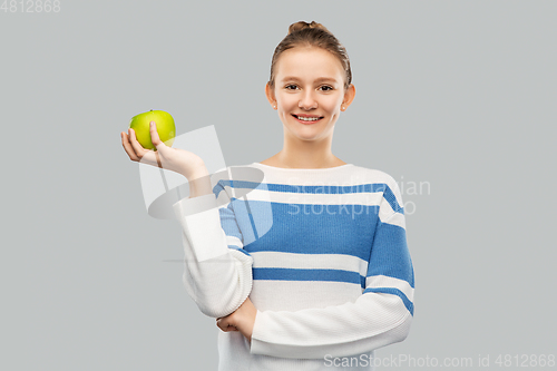 Image of smiling teenage girl in pullover with green apple