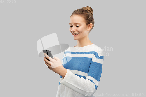Image of happy smiling teenage girl using smartphone
