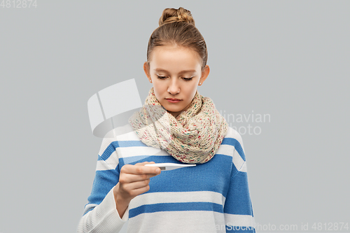 Image of sick teenage girl in scarf measuring temperature
