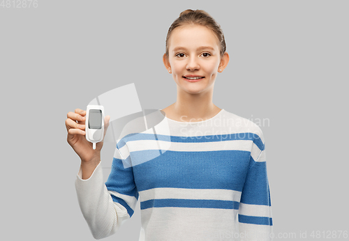 Image of happy smiling teenage girl with glucometer