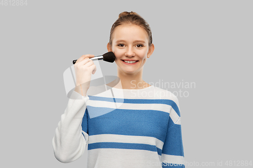 Image of happy smiling teenage girl with make up brush