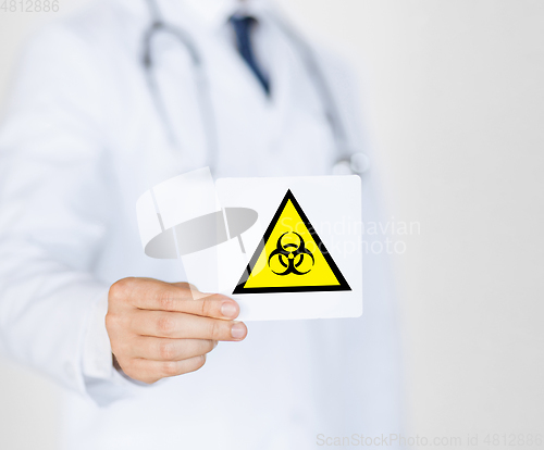 Image of male doctor holding boihazard caution sign