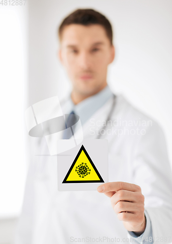 Image of male doctor holding coronavirus caution sign