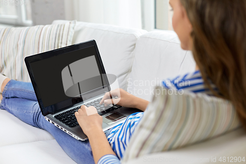 Image of close up of teenage girl typing on laptop at home