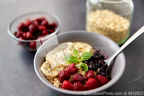 Image of cereal breakfast with berries, banana and spoon