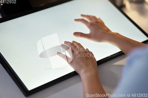 Image of hands on led light tablet at night office