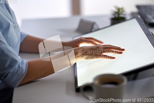 Image of hands on led light tablet at night office