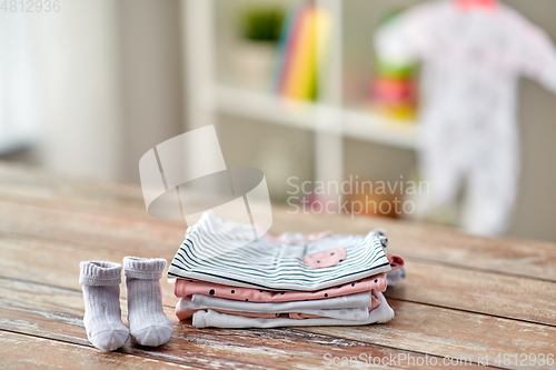 Image of baby clothes on wooden table at home