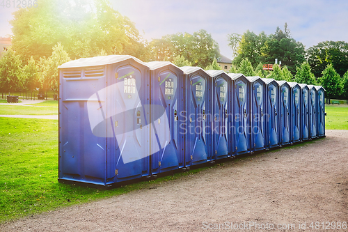 Image of Row of Blue Portable Toilets in Park