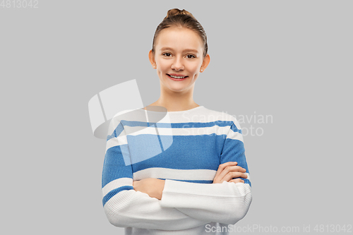 Image of smiling teenage girl with crossed arms in pullover