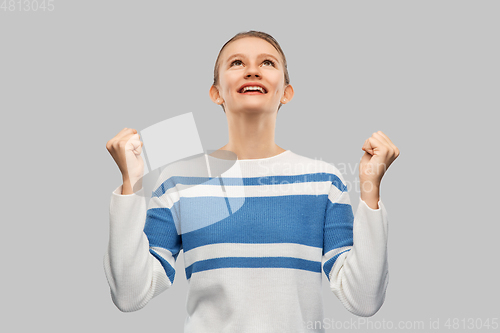 Image of happy teenage girl in pullover celebrating success