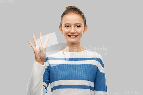 Image of smiling teenage girl showing four fingers