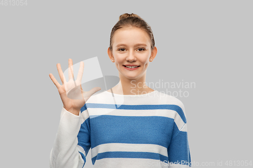 Image of smiling teenage girl showing five fingers