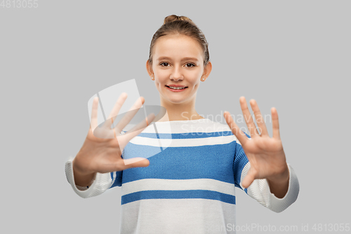 Image of smiling teenage girl showing hands or ten fingers