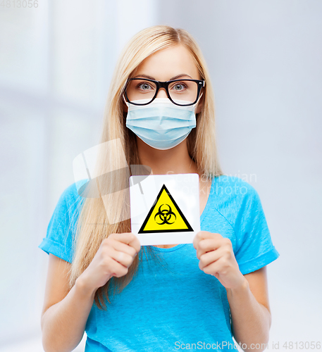 Image of woman in medical mask with boihazard caution sign