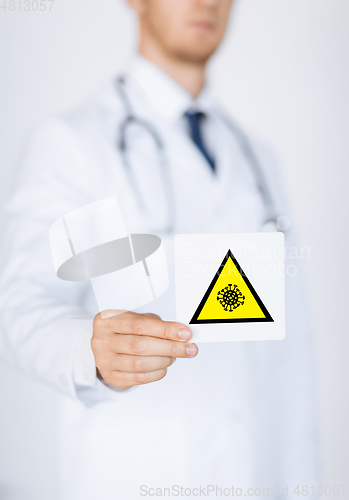 Image of male doctor holding coronavirus caution sign