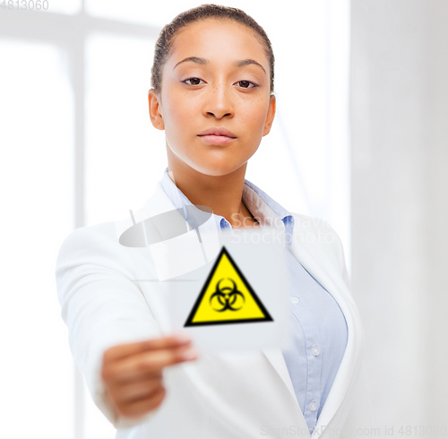 Image of female doctor holding boihazard caution sign