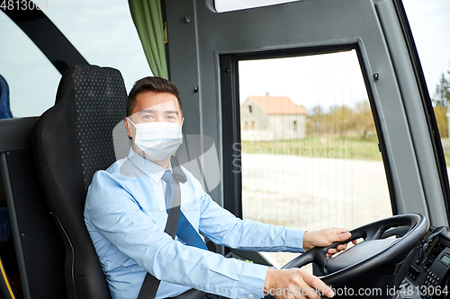Image of driver in medical mask driving intercity bus