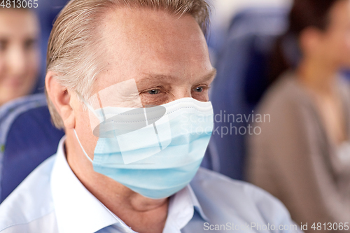 Image of senior passenger in mask in travel bus or airplane