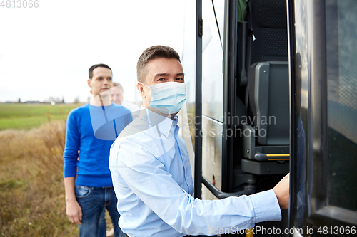 Image of male passenger in medical mask boarding travel bus