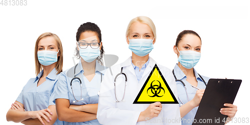 Image of female doctor and nurses with biohazard sign