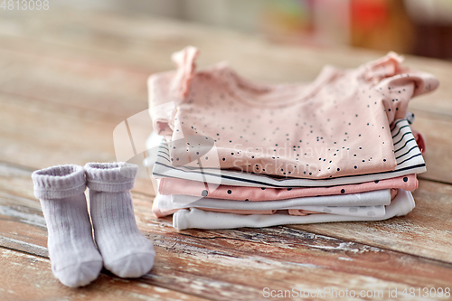 Image of baby clothes on wooden table at home