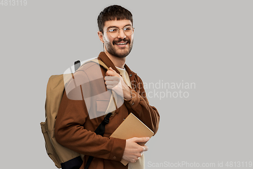 Image of smiling young man with backpack and diary