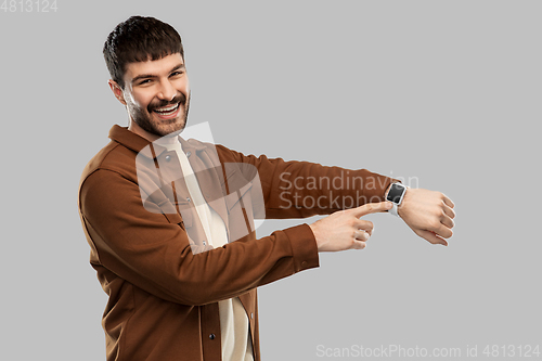 Image of smiling young man with smart watch