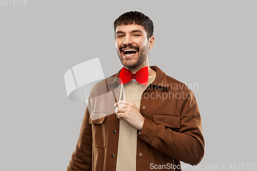 Image of smiling man with red bowtie party accessory