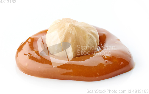 Image of hazelnut in melted caramel drop