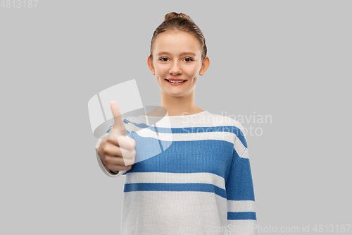 Image of smiling teenage girl showing thumbs up