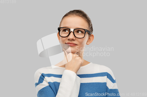 Image of thinking teenage student girl in taped glasses