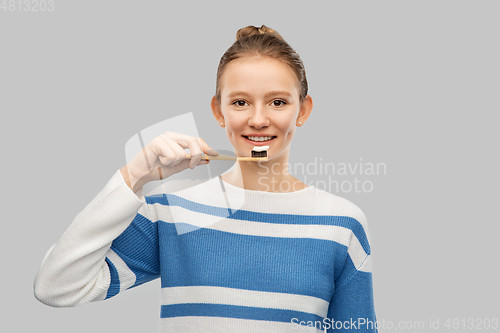 Image of happy teenage girl brushing teeth with toothbrush