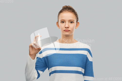 Image of teenage girl with nasal spray over grey background