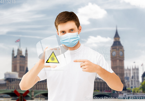 Image of man in mask with coronavirus sign in england