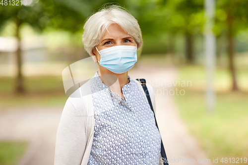 Image of senior woman in protective medical mask in park