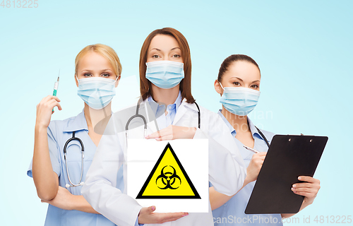 Image of female doctor and nurses with biohazard sign