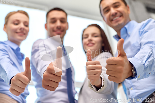 Image of happy smiling business team showing thumbs up