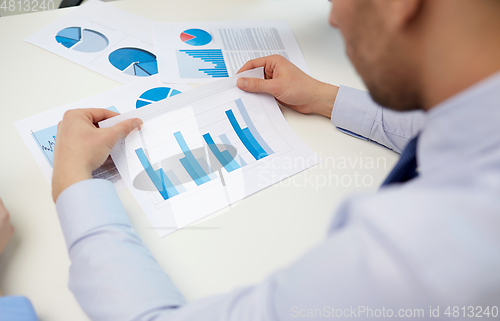 Image of close up of businessman's hands with charts