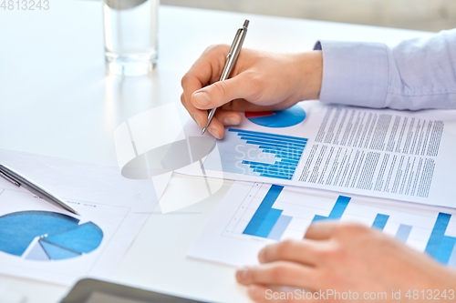 Image of close up of businessman's hands with charts