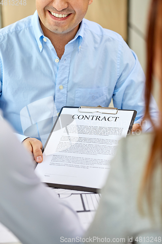 Image of realtor showing contract document to customers